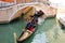 Gondolier sailing with tourists in a gondola along one of the ca