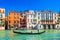 Gondolier and tourists on gondola traditional boat sailing on water of Grand Canal in Venice