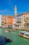 Gondolier and tourists on gondola traditional boat sailing on water of Grand Canal in Venice