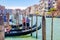 Gondolier and tourists on gondola traditional boat sailing on water of Grand Canal in Venice