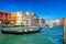 Gondolier and tourists on gondola traditional boat sailing on water of Grand Canal in Venice