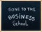 Gone to the business school message written with white chalk on wooden frame blackboard