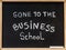 Gone to the business school message written with white chalk on wooden frame blackboard