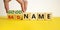 Good or bad name symbol. Businessman turns wooden cubes and changes words `bad name` to `good name`. Beautiful yellow table, w