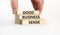 Good business sense symbol. Concept words `Good business sense` on wooden blocks. Businessman hand. Beautiful white background.