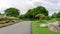 Good care landscapes public park and garden design, asphalt road in gardens decorated with stone and colorful flowering plant