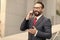 A good deal! Bearded businessman speaks by phone and laughs.View of a Young attractive business man in glasses using smartphone.