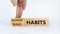 Good habits symbol. Businessman turns a wooden block and changes words `bad habits` to `good habits`. Beautiful white backgrou