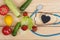 Good healthy and diet concept - Blackboard in shape of heart, stethoscope and vegetables, fruits and berries