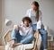 Good looking couple of young people in love at home in a cozy armchair, wear jeans and white shirts