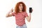 Good-looking happy bright redhead curly girl 25s hold smartphone pointing looking device display showing friend
