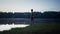 Good looking man in swim shorts going to the lake through the grass and looking at the water