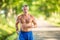 Good-looking older man runs topless outdoors in the nature to stay in shape