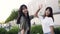 Good-looking pleasant young asian women giving each other high five and posing on camera with cute smiles near shopping