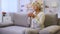 Good-looking senior lady drinking tea sitting on home sofa, enjoying weekend