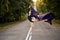 Good-looking slim ballerina dancer jumping while dancing, in forest