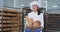 Good looking young baker lady holding a fresh vintage basket with organic bread and looking straight to the camera and