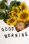 Good Morning. A bouquet of large sunflowers and hot coffee. Sunflower arrangement flat lay style on background white