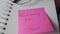 Good morning Friday, written on a post it glued to a notepad with glasses on top.