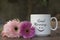 Good morning. A positive morning spirit greeting with happy smiling face emoticon concept coffee cup with two soft pink flowers.