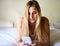 Good morning social media. a beautiful young woman using her smartphone while relaxing on her bed.