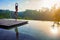 Good morning with woman yoga meditating on sunrise background.