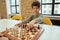 Good move. Observant little boy making a move while sitting in the classroom and playing chess on the chessboard