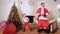 Good New Year spirit: Christmas tree, gift bag, fireplace - Santa and cute elf dancing. Slowmotion