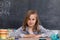 A good schoolgirl sits upright on the school bench and smiles softly