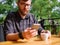 Goodly young man working on tablet while sitting outdoors . Business concept.