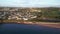 Goodrington Sands, Devon, England: Drone Views: Seafront promenade, houses, land horizon, sandy beach and beach huts