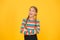 Goods for teens. Adorable girl beautiful face. Little girl. Small child with cute braids hairstyle on yellow background
