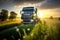 Goods truck driving in rural road at sunset. Farm field background.