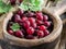 Gooseberries in the wooden bowl on the table.