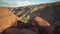 Goosenecks canyon become visible behind big red rocks at sunset