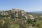 Gordes beautiful old village with pastel buildings on the hill surrounded by mountains in Vaucluse, Provence, France