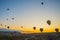 Goreme, Turkey. Numerous hot air balloons all lift into the air just after dawn
