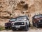 Goreme, Turkey - October 2019. Three Land Rover offroad cars park in front of typical cappadocian cave house remains