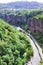 Gorge of the Arpa River. View of the mountains, the river, the road and the blue sky. The city of Jermuk, Armenia