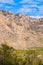 Gorge high wall mountain rock foot blue bright sky clouds walk vertical photo