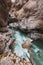 Gorge with a mountain river with a vibrant turquoise water between the rocks.