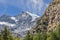 Gorge overgrown with green coniferous forest and steep granite rocks in Gran Paradiso National Park