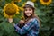 Gorgeous, adorable, energetic, female farmer standing near a sunflower with a smiley face, in the middle of a beautiful golden