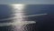 Gorgeous aerial footage of the vast blue rippling ocean water with waves rolling into the beach with a gorgeous clear blue sky