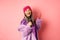 Gorgeous asian senior woman singing karaoke in mic, perform song and looking happy, standing over pink background