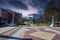 A gorgeous autumn landscape at the Decatur Square with red and yellow autumn trees, lush green trees and a round blue pergola