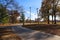 A gorgeous autumn landscape in the park with smooth footpaths surrounded by gorgeous autumn colored trees and grass