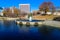 A gorgeous autumn landscape in the park with a still green lake and a water fountain in the center of the lake