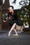 Gorgeous ballerina in black outfit dancing in the city streets