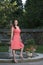 Gorgeous biracial woman poses wearing pink dress in garden